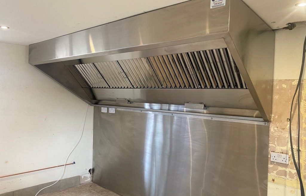 Kitchen canopy and wall cladding manufactured in DP1 fine grain stainless steel.